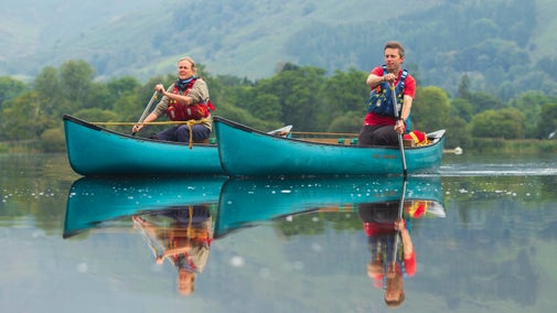 Two volunteers in canoes on the lake at Grasmere, lake District
